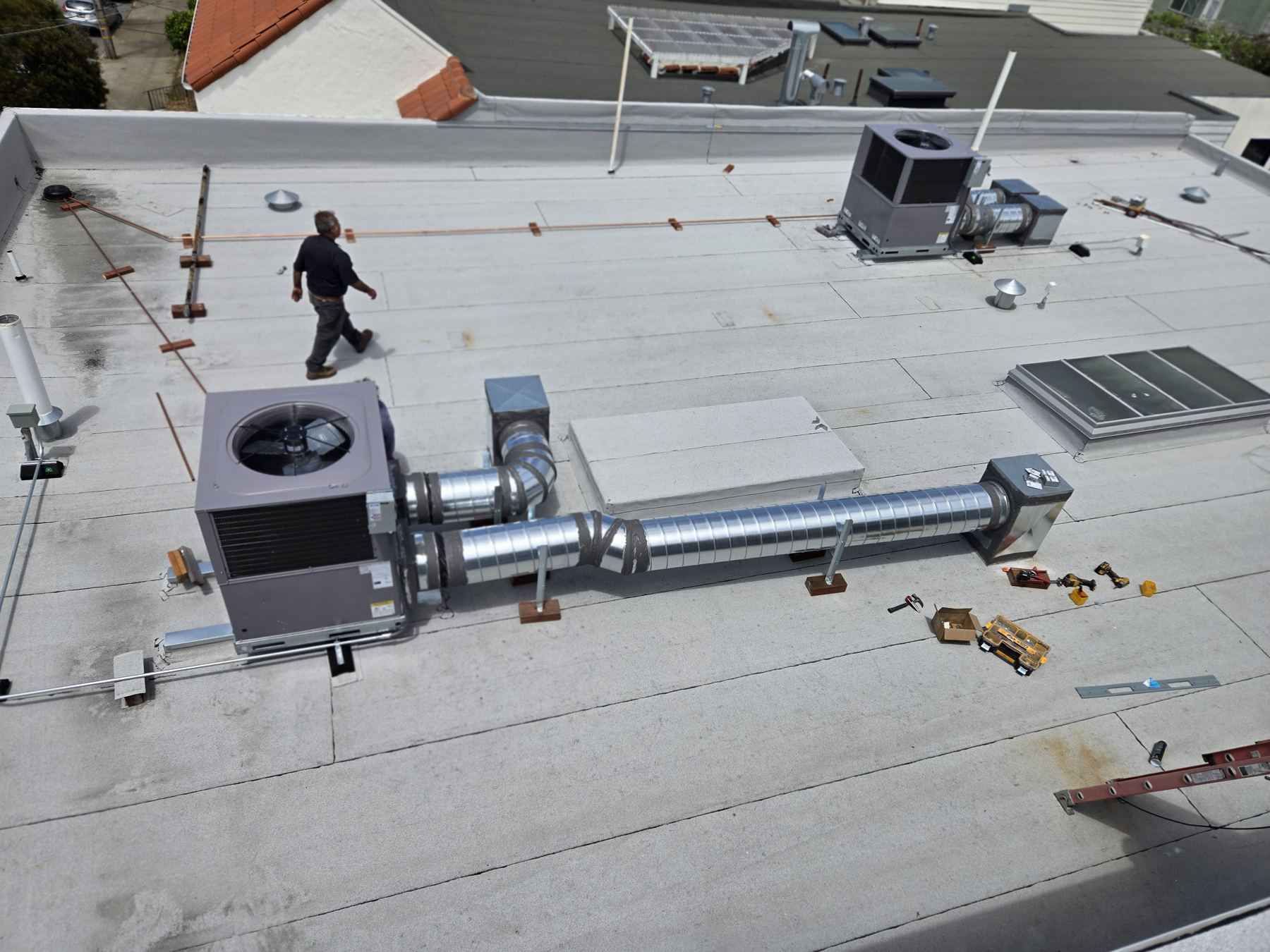 Unidad HVAC comercial en un techo, con ductos